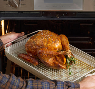 steam griddle pan, oven rack, oven mats with cooked turkey being taking out of oven